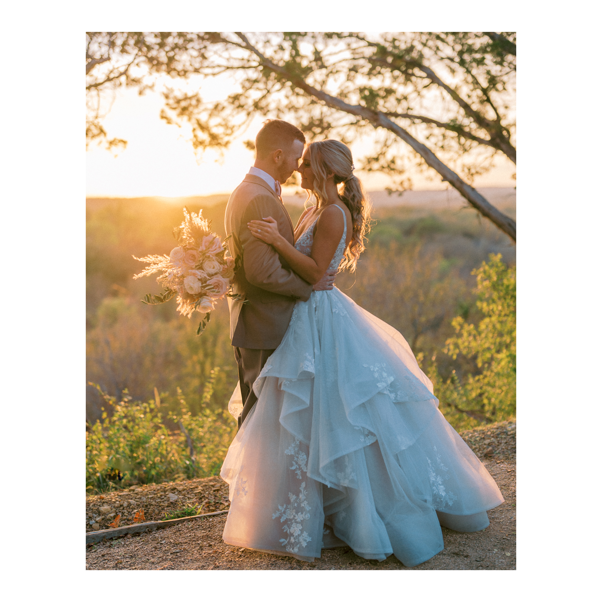 Newlywed couple embracing at sunset in an outdoor wedding setting in Fort Worth Texas with bride in a lace dress and groom in a beige suit.